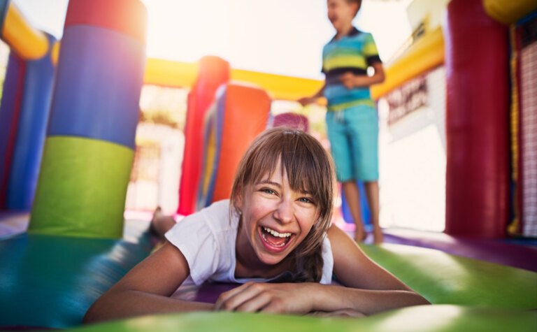 A young girl laughing on a bouncy castle