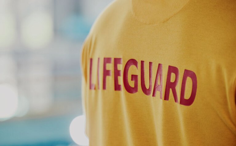 The back of a person wearing a lifeguard t-shirt