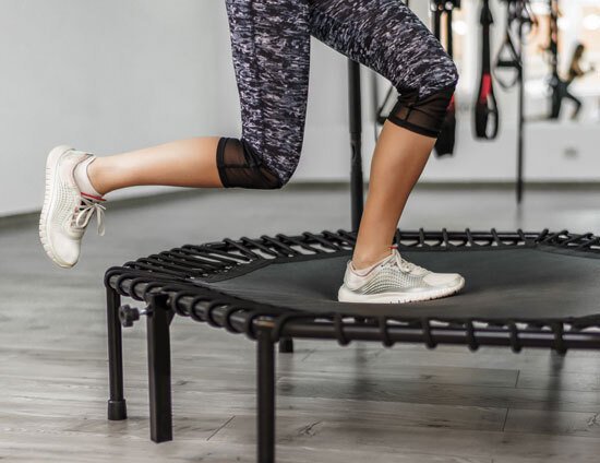 A lady using a mini trampoline in a fitness class