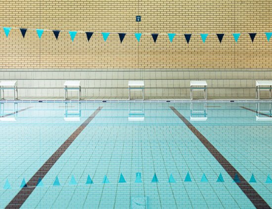 An indoor swimming pool with lane markers and bunting